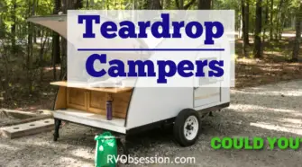 Pin with a car pulling a teardrop camper down a wooded road.