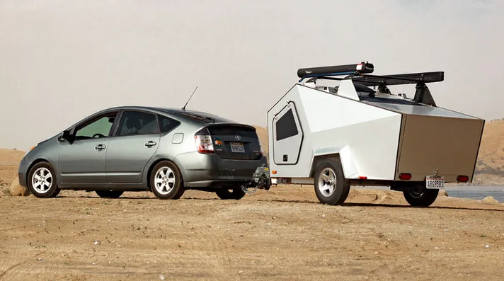 Geometric shaped teardrop camper hitched to a Prius