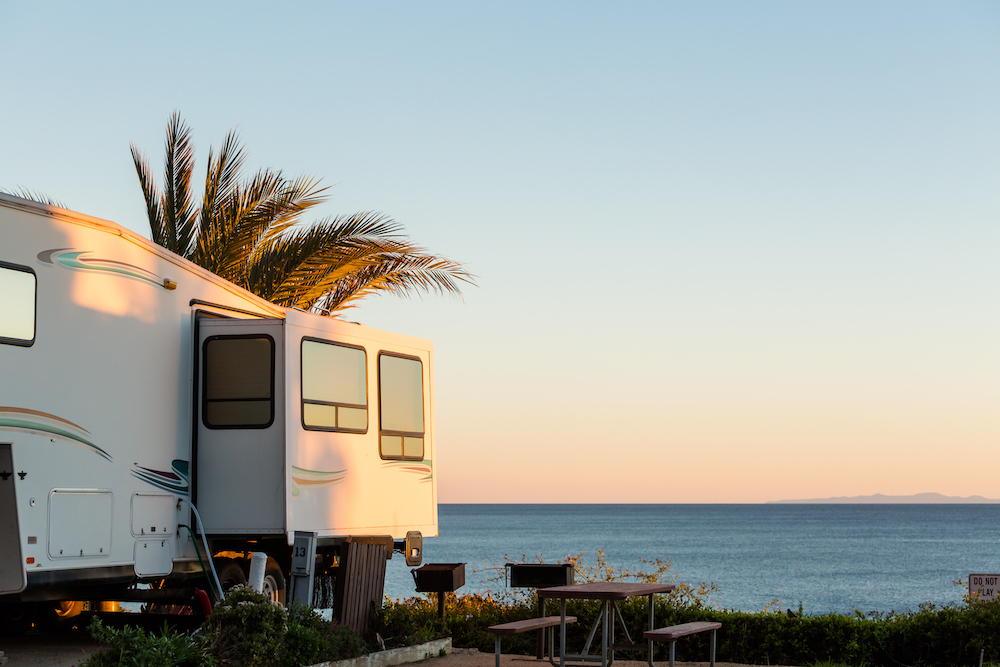RV camped beside the ocean at dusk.