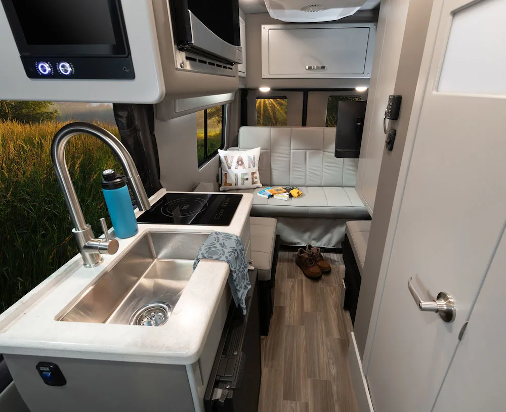 Interior view of the Fleetwood RV 2024  Xcursion Class B RV showing the kitchen and seating area.