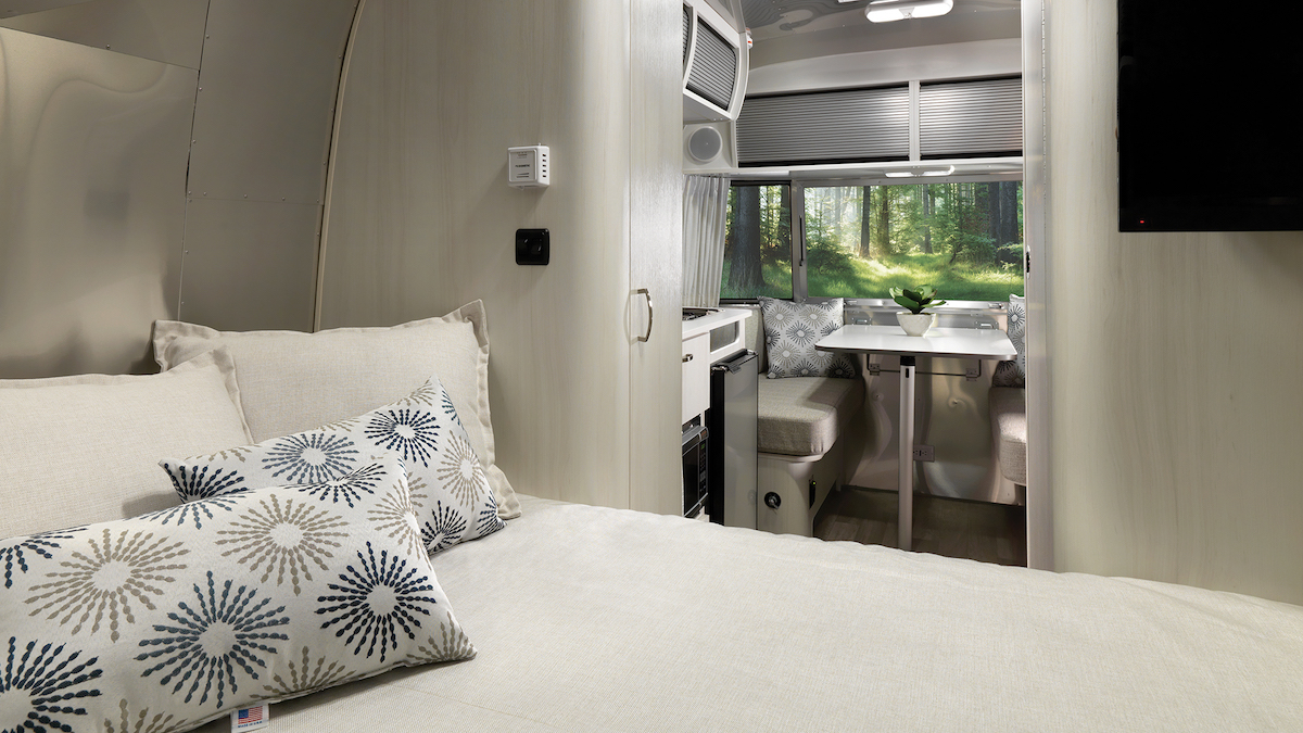 Inside view of the Airstream Bambi 16RB travel trailer, looking from the bed to the dining area.