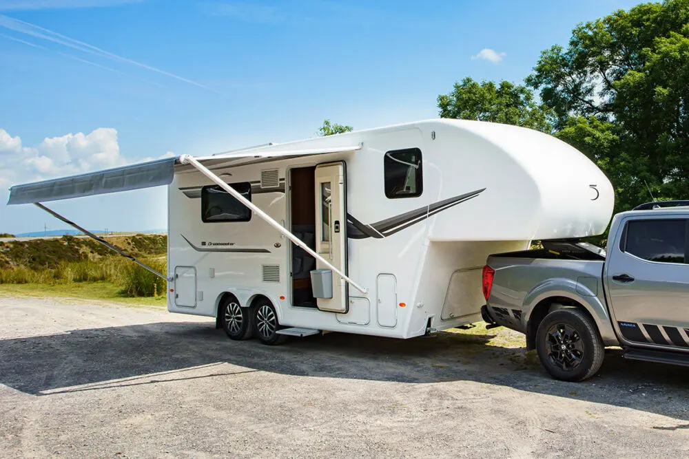 Exterior of the DreamSeeker fifth wheel camper by Fifth Wheel Co with the door open and the awning extended out.