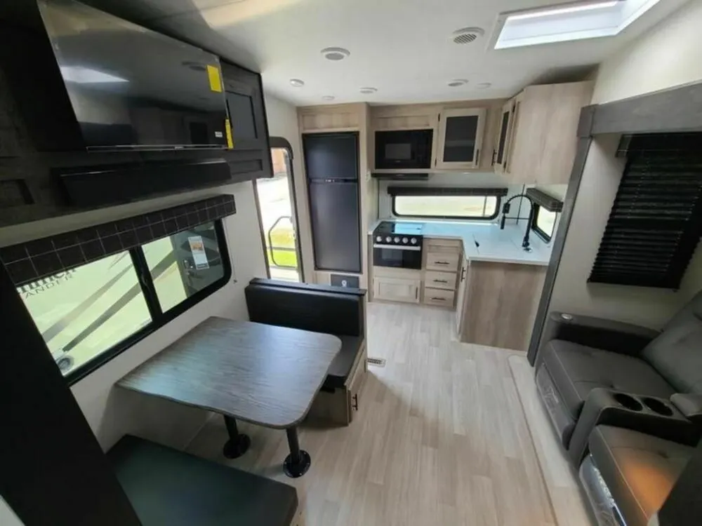 Interior view of the KZ RV Sportsmen 231RK fifth wheel trailer shwoing the kitchen and living areas.