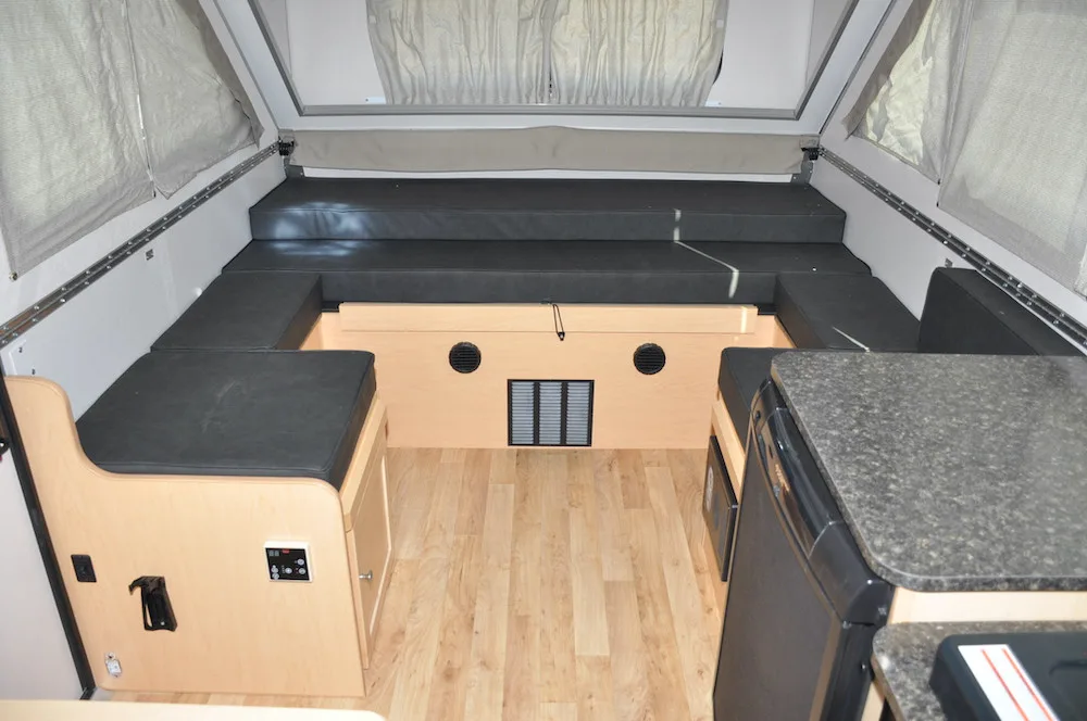 Interior of an Aliner LXE camper showing the dining area that converts to a bed.