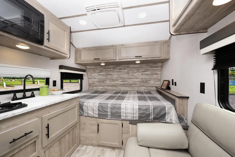 Interior view of the Ameri-Lite 14RE travel trailer showing the bed area.