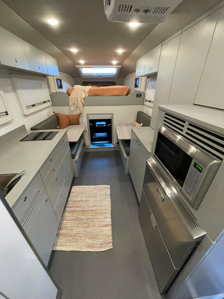 Interior photo of the Global Expedition Vehicles Adventure XT RV showing the living area and the bed above the cab.