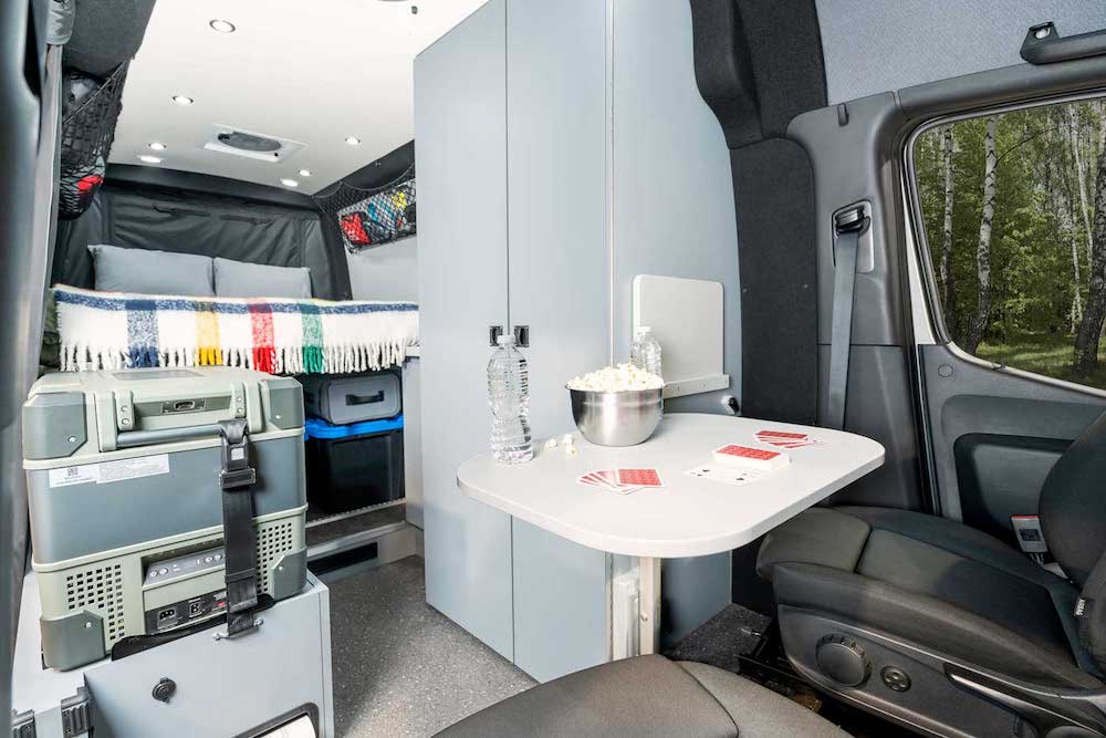 Interior view of the Pleasure Way REKON 4x4 camper van showing the kitchen, living and bedroom areas.