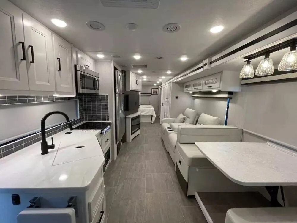 Interior view of a Coachmen Encore 325SS Class A motorhome showing the kitchen and dining area.